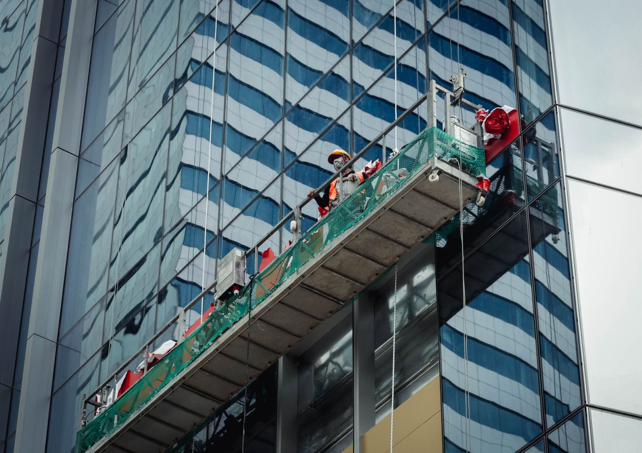 Un travailleur urbain nettoie les vitres d’un immeuble de grande hauteur à Ho Chi Minh City, Vietnam.